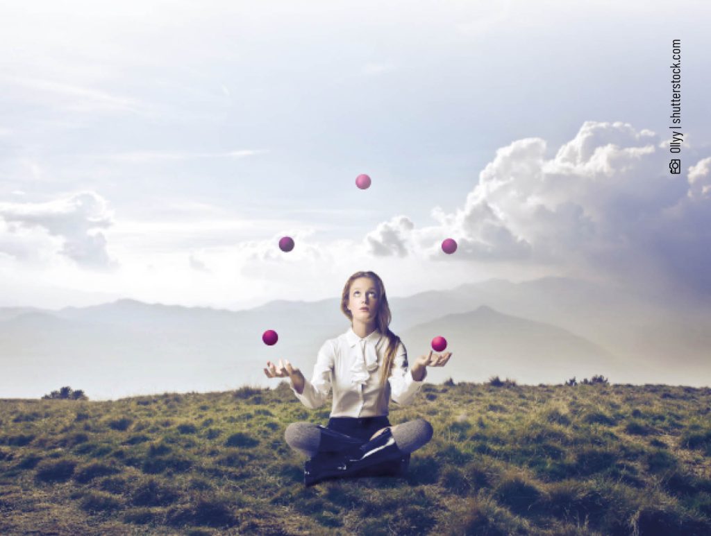 Jonglierende Frau auf einer Wiese