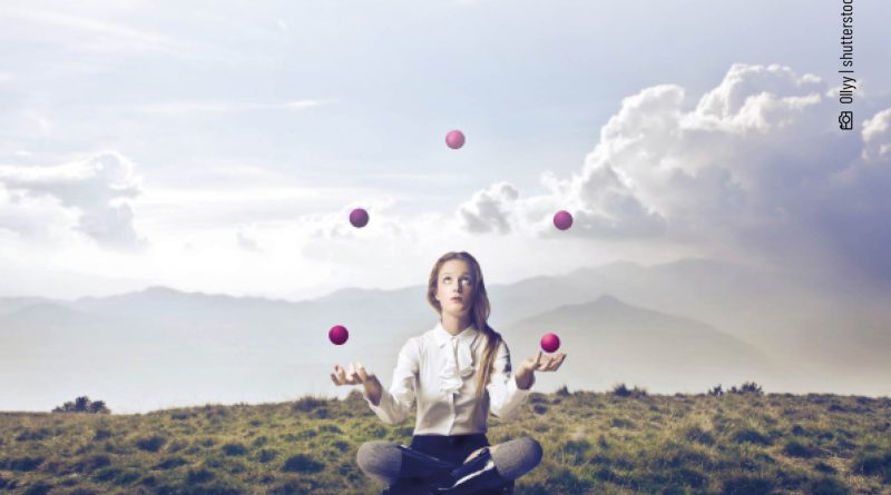 Jonglierende Frau auf einer Wiese