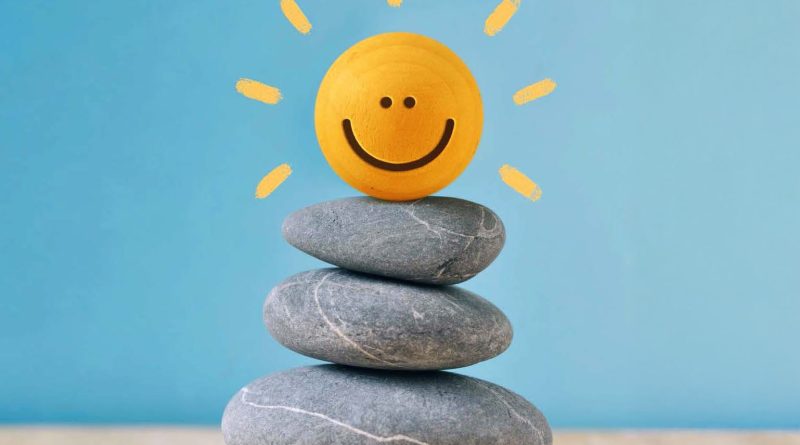 Lächelnde Sonne auf gestapelten Steinen