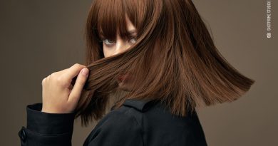 Modische Frau, die ihr Gesicht elegant mit ihren Haaren verdeckt