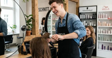Junger Friseur Azubi beim Föhnen von Haaren