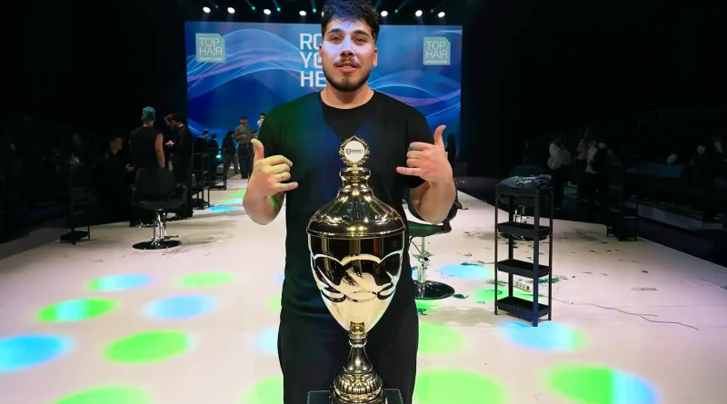 Junger Mann posiert mit gewonnenem Pokal